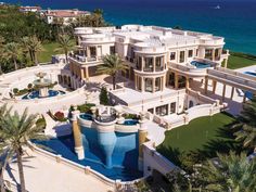 this is an aerial view of a mansion on the beach in palm trees and blue water