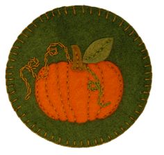 an orange pumpkin is on a green plate with gold trimmings and a leaf in the center