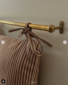 a pillow with a gold handle hanging from it's side next to a wall