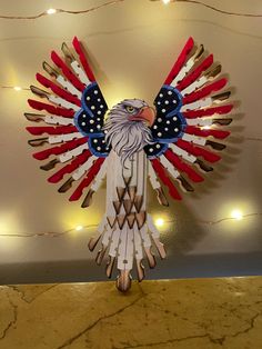 an eagle made out of toothpicks on top of a counter with lights in the background