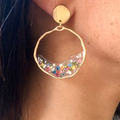 a close up of a person wearing some kind of earring that has sprinkles on it