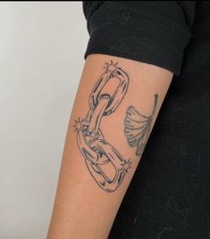 a woman's arm with a tattoo on it that has a chain attached to it