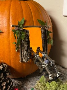 a large pumpkin sitting on top of a counter next to pine cones and other decorations