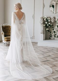 a woman in a wedding dress standing on the floor with her back to the camera