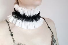 a woman wearing a black and white collar necklace