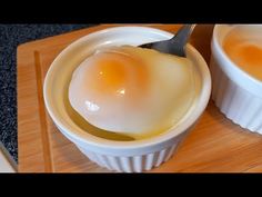 two white bowls filled with eggs on top of a wooden cutting board