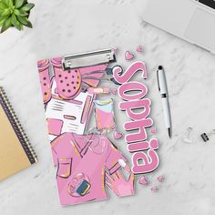 a pink notebook with the word spring on it next to a pen, laptop and notepad