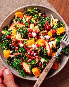 a salad with oranges, kale and pomegranate in a bowl