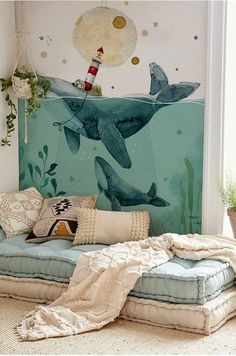 there is a bed that has two dolphins on it and a lighthouse in the background