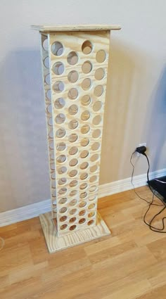 a tall white vase sitting on top of a hard wood floor next to a wall