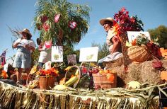 some people are sitting on hay bales and decorations