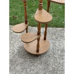 three tiered wooden table sitting on top of a sidewalk