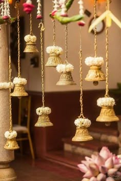 the bells are decorated with white flowers and gold chains hanging from it's sides