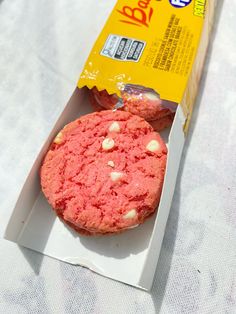 a package of cookies sitting on top of a white table next to a cupcake