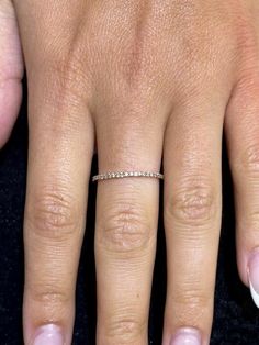 a close up of a person's hand with a wedding ring on her finger