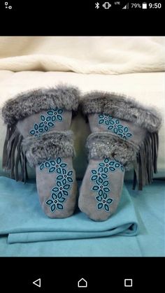 two pairs of slippers are sitting on top of a blue blanket with fringes