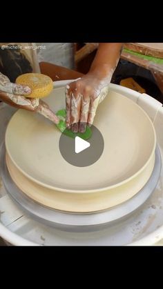 a person is making plates with their hands on top of each other in a bowl