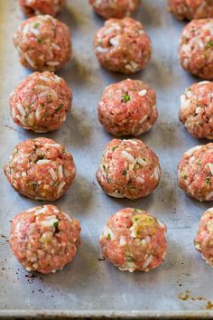 raw meatballs on a baking sheet ready to go into the oven