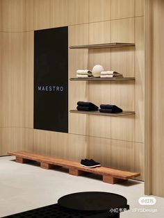 the interior of a store with wooden shelves and black shoes on display in front of it