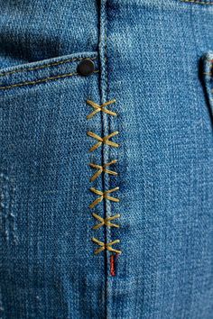 a pair of blue jeans with yellow laces on them