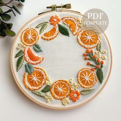 an embroidery project with oranges and leaves on it