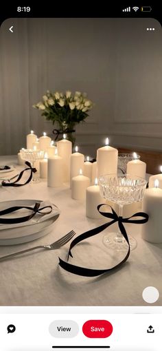 a table topped with white candles and plates