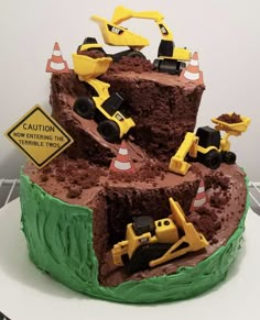 there is a cake that has construction trucks on the top and dirt in the middle