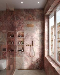 a bathroom with marble walls and flooring next to a bathtub, shower head, and window