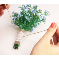 someone is stringing the flowers together with twine