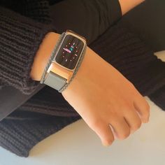 a woman wearing an apple watch on her wrist with a braided bracelet around her wrist