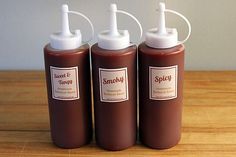 three brown bottles with white caps sitting on top of a wooden table