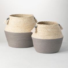 two gray and white baskets sitting next to each other