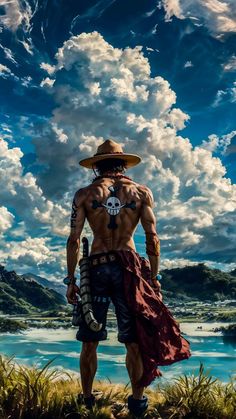 a man with no shirt on standing in front of the ocean and clouds above him