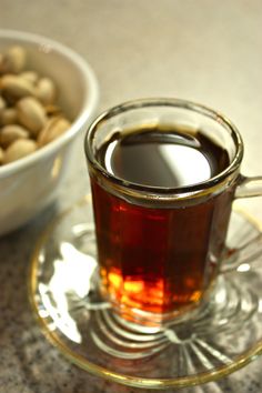 there is a cup of tea and some nuts on the table