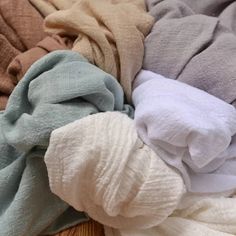 a pile of folded clothes sitting on top of a wooden floor