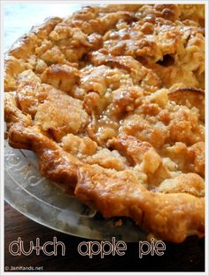 a pie with some toppings sitting on top of a glass platter, ready to be eaten