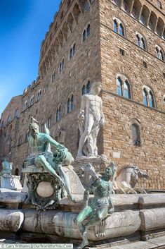 the fountain in front of the building has statues on it