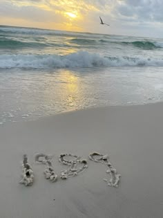 the word hope is written in the sand at the beach as the sun goes down