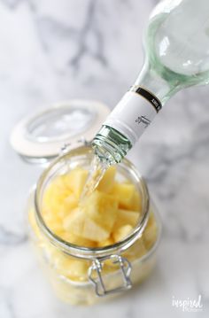 a glass jar filled with sliced pineapples on top of a marble countertop