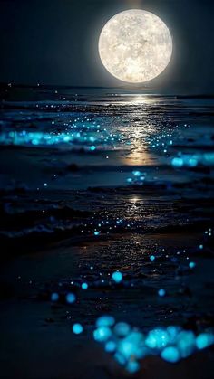 the full moon shines brightly over the ocean at night with blue bubbles floating in the water