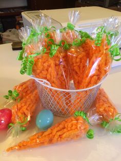 carrots wrapped in plastic sitting on a table next to an easter egg and candy