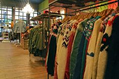 the clothing rack is full of sweaters and hats