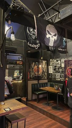 the interior of a restaurant with tables and booths, decorated with skulls on black fabric