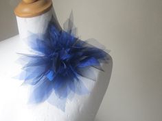 a white mannequin with a blue flower on it's head and neck