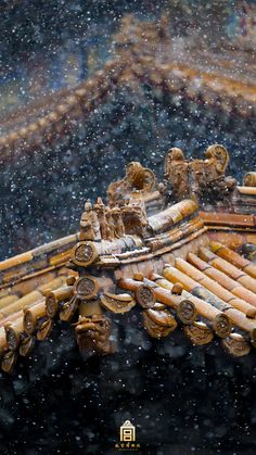 the roof of an old building is covered in snow and has wooden carvings on it