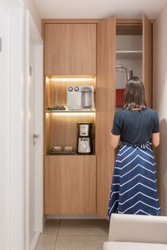 a woman standing in front of a wooden cabinet