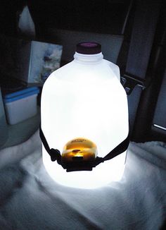 a bottle with a light inside it sitting on a blanket in the back of a car