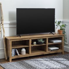 a flat screen tv sitting on top of a wooden entertainment center in a living room