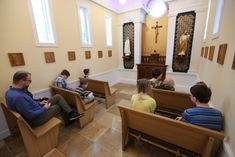 people are sitting in pews at the alter