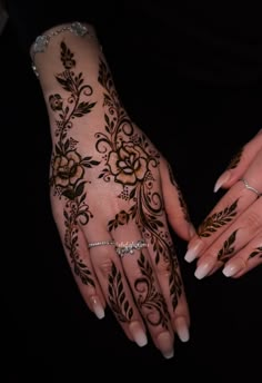 two hands with henna tattoos on them